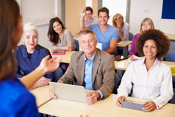 Mature Students In Further Education Class With Teacher