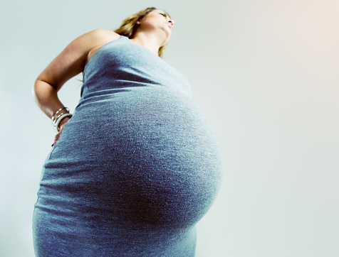 Muy atrás mujer embarazada con el dolor toma de ángulo bajo photo
