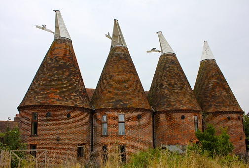 Medieval granaries for a grain named oast used in brewing beer now serve as family houses.