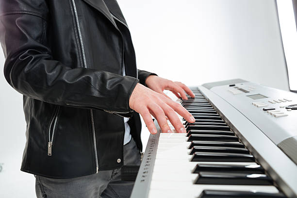 istock Hands of young man standing and playing on synthesizer 511871088