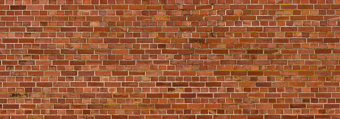 Rustic brick wall with terracotta bricks and cement grout.