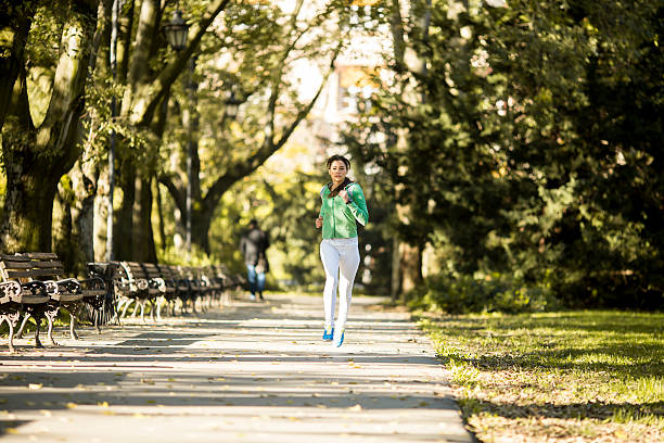 istock Young woman running in the park 511875706