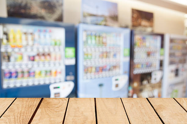 istock Empty top wooden table and blurred image of vending machine 511875716