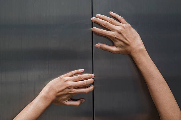 istock woman hands try to stop doors of the closed elevator 511875832