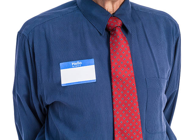Senior Man in Blue Shirt with Tie and Name Tag stock photo