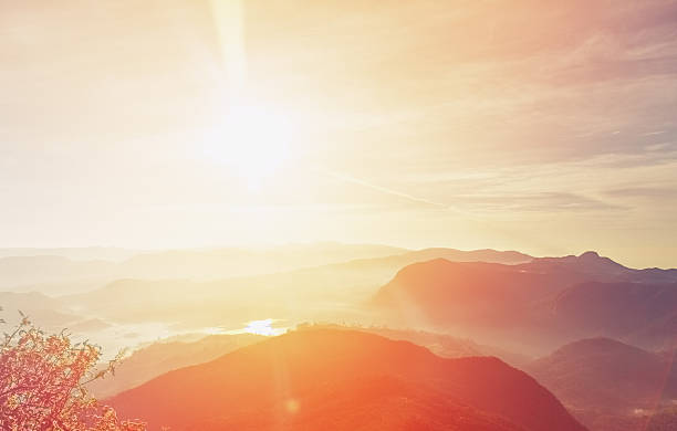 Sunrise over Adam's peak, Sri Lanka Sunrise over Adam's peak, Sri Lanka. Shot taken from the monastery, which is located right on the top of the peak. View to the Peak wilderness sanctuary. Range of mountains with first sunrise light in the centre of composition, smoky mountains silhouette and colorful morning sky with few clouds on the background. Camera used: Canon 5D mk III lanka stock pictures, royalty-free photos & images