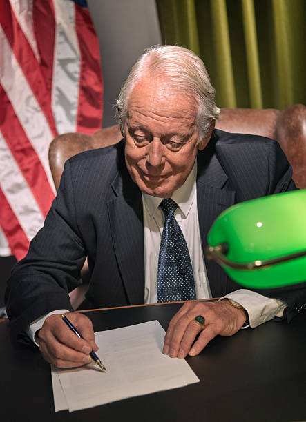 istock Big boss president writing behind desk with american flag. 511884543