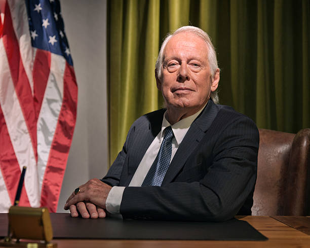 istock Big boss president sitting behind desk with american flag. 511884555