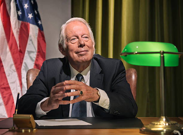 istock Big boss president sitting behind desk with american flag. 511884573