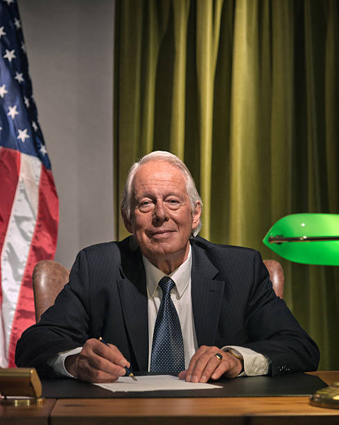 istock Big boss president sitting behind desk with american flag. 511884589
