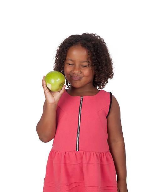 Little African- American girl eating Granny Smith Apple stock photo