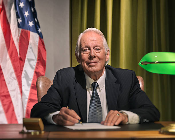 istock Big boss president sitting behind desk with american flag. 511888335