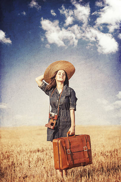 istock Brunette girl with suitcase on countryside. 511888463
