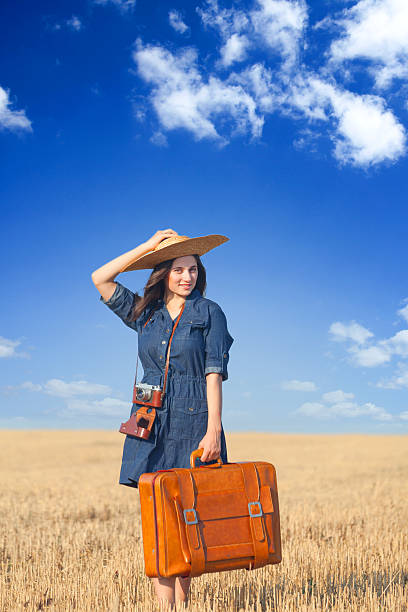istock Brunette girl with suitcase on countryside. 511888465