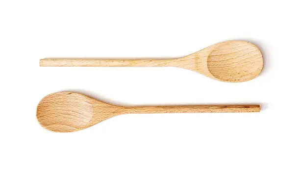 Two wooden spoons on the white background. Kitchen equipment.