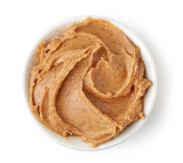 istock Peanut butter in round dish isolated on white background 511918374