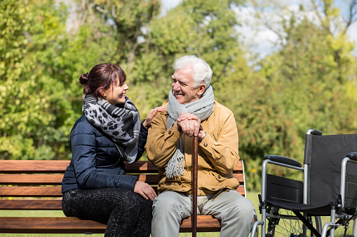 Elder man and carer in the park