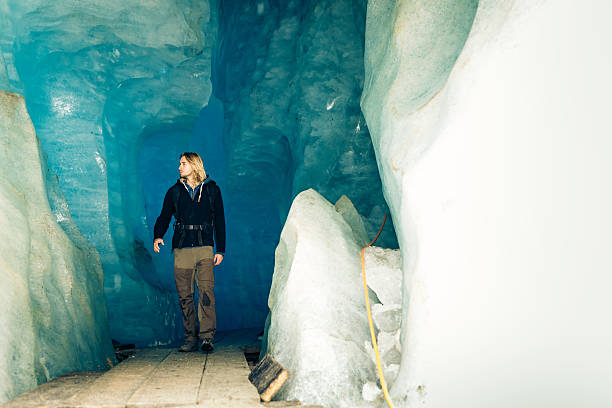 istock Young Man Hiking Through Glacier Cave 511919010