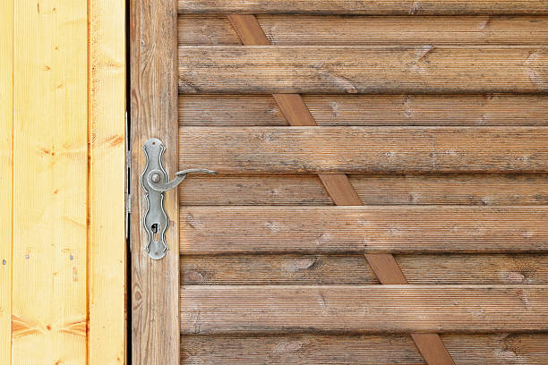istock Weathered wooden doors in brown and yellow with metal handle 511925946