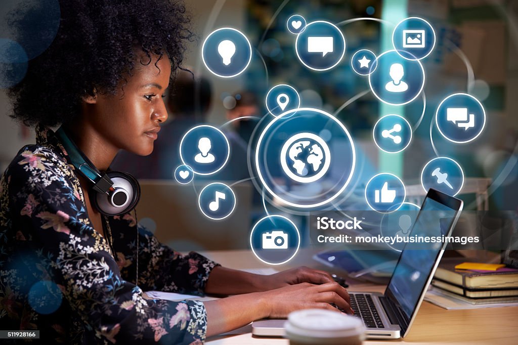 Young woman on social media with holographic icons Conceptual Image Of Young Woman Using Social Media On Laptop With Holographic Icons Projected From Screen Community Stock Photo