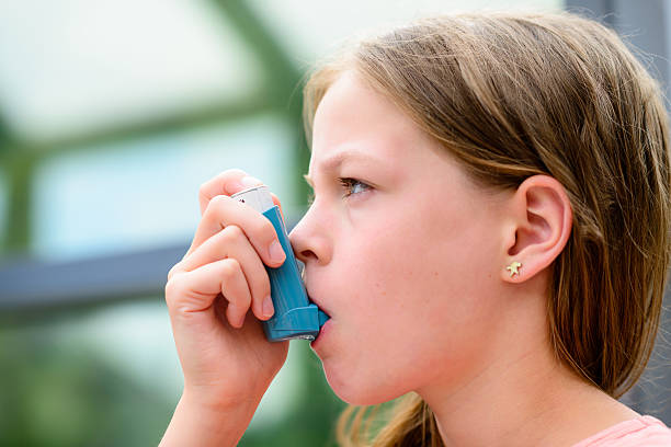 istock Girl uses an inhaler during an asthma attack 511928320
