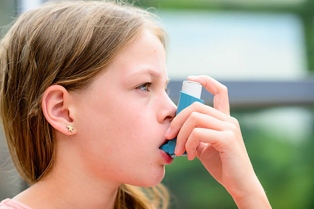 istock Girl uses an inhaler during an asthma attack 511928542