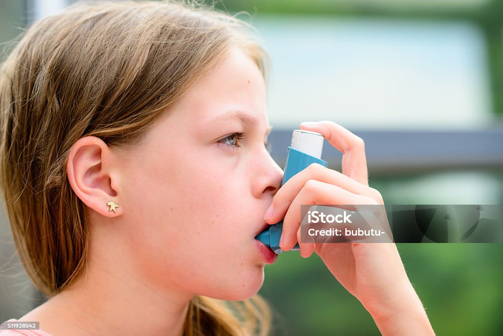 Girl uses an inhaler during an asthma attack Girl uses an inhaler during an asthma attack, close-up Allergy Stock Photo