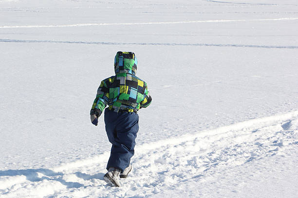 istock The child in a color jacket running on snow 511928866