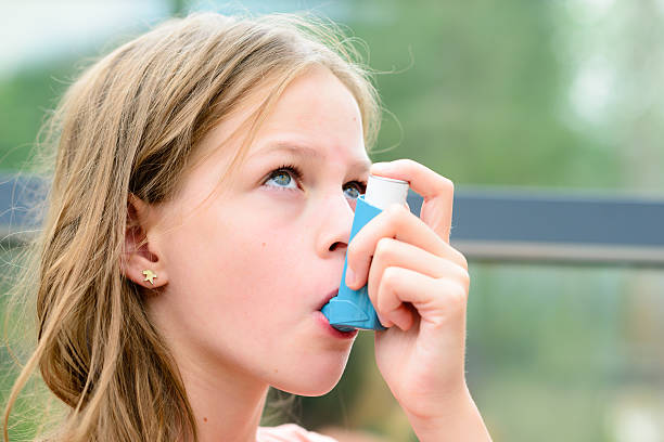 hübsches mädchen mit asthmainhalator - asthmatic child asthma inhaler inhaling stock-fotos und bilder