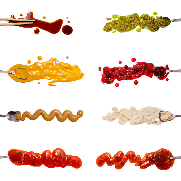Set of 8 savory sauces and toppings isolated on white Spoons dipped in the sauces. Soy sauce, curry, mustard, barbecue sauce. Pesto, cranberry sauce, horseradish, chili sauce. Set for menu. flat lay, top view barbeque sauce photos stock pictures, royalty-free photos & images