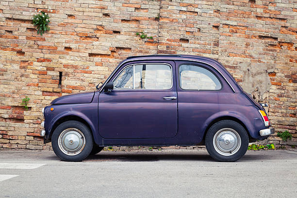 Old Fiat Nuova 500 city car, side view Fermo, Italy - February 11, 2016: Old Fiat Nuova 500 city car produced by the Italian manufacturer Fiat between 1957 and 1975 stands in a town, side view little fiat car stock pictures, royalty-free photos & images