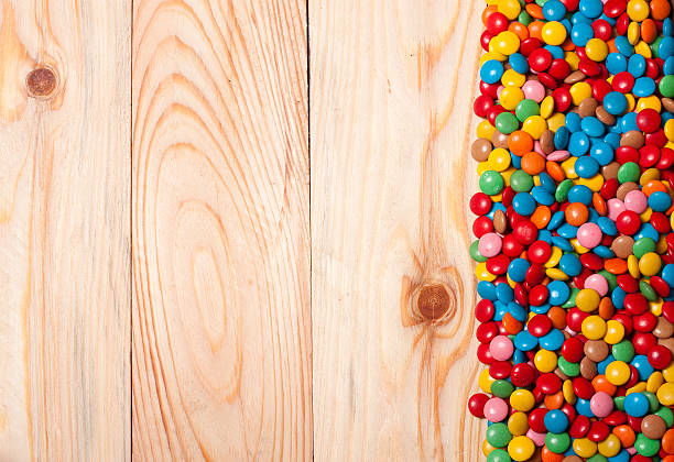istock Frame of colorful candy on wood background 511932056
