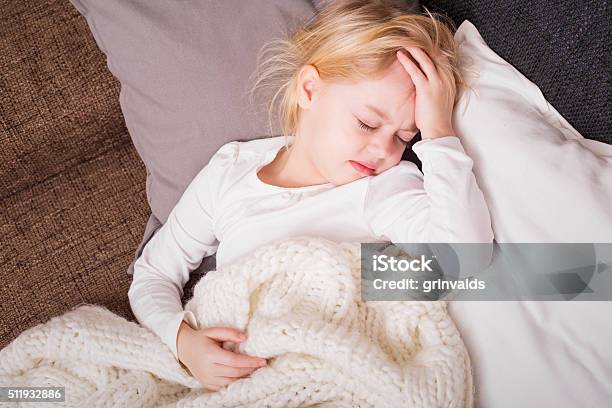 Poco Niño Enfermo Y Sosteniendo Su Mano A La Frente Foto de stock y más banco de imágenes de Niño