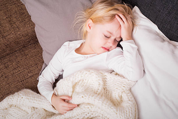 piccolo bambino arrivare malati e con la mano sulla fronte - unwell foto e immagini stock