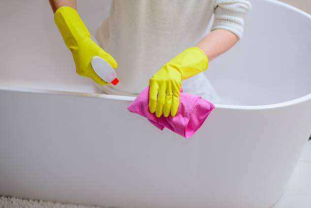 istock Female hands with yellow rubber gloves cleaning bath 511937914