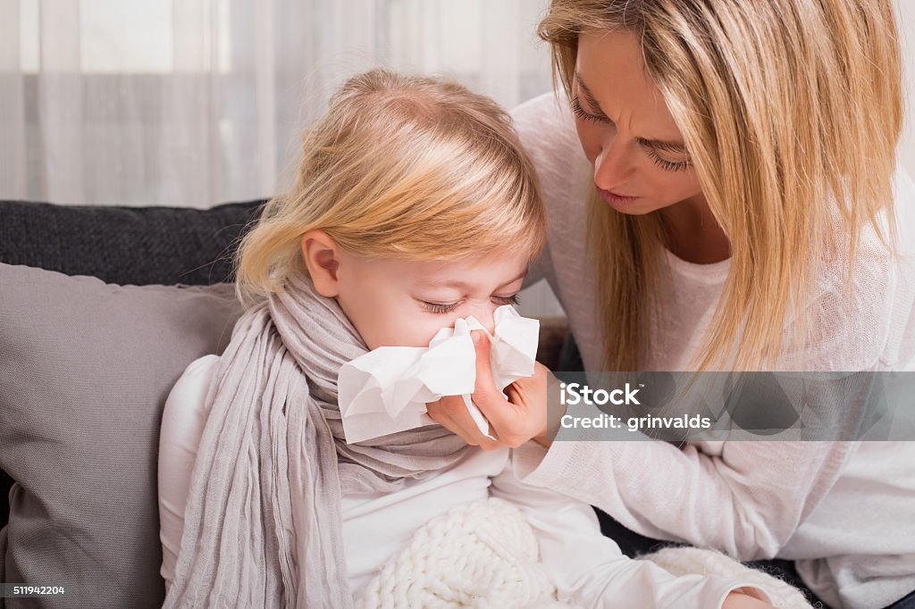 Little girl with cold and blowing her nose Child Stock Photo