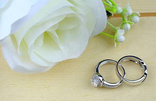 Photo of wedding rings with rose flowers