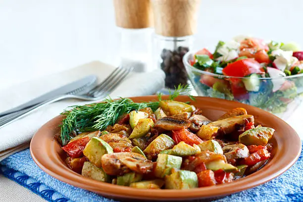 Roasted vegetables on a rustic plate. Salad with fresh vegetables