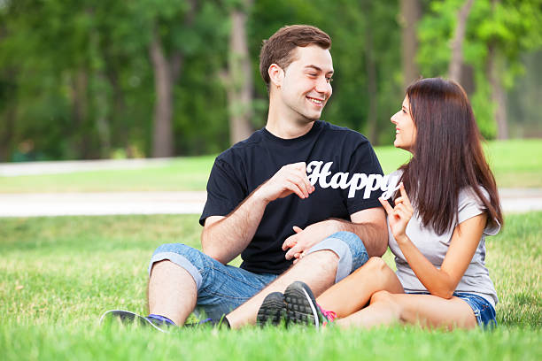 nastolatek para z słowa szczęśliwy w parku. - happy group zdjęcia i obrazy z banku zdjęć