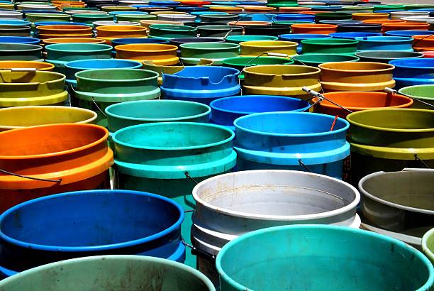 Buckets, Buckets and more Buckets These are a bunch of buckets lined up in the parking lot of Owen Park in Madison, Wisconsin.  I believe they were growing seedlings in them.  It had recently rained so all that was visible in them was murky water. michael owen stock pictures, royalty-free photos & images