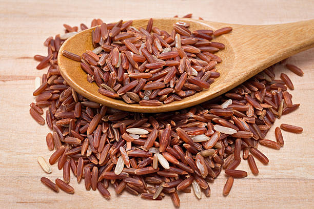 istock Brown rice on wooden spoon 511951305