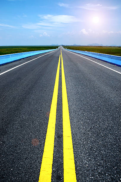 istock Empty road and the yellow traffic lines with blue sky. 511969741