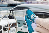 Pair of human legs in bright topsiders on yacht
