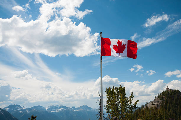 Canadian flag on mountain Canadian flag on mountain rocky mountains banff alberta mountain stock pictures, royalty-free photos & images