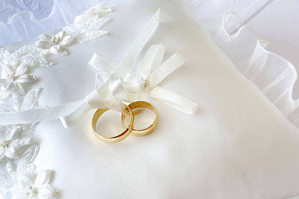 istock Gold wedding rings on a pillow with ribbons 511974249