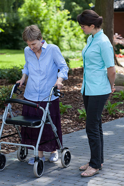 istock Nurse watches as an elderly woman walks 511976127