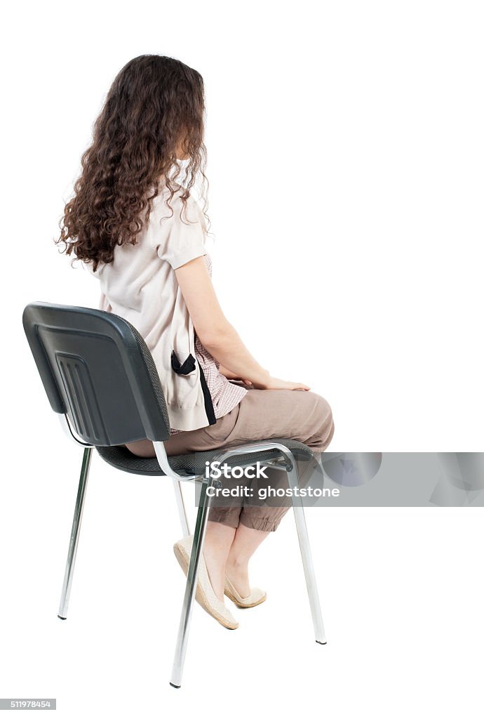 back view of young beautiful  woman sitting on chair. back view of young beautiful  woman sitting on chair.  girl  watching. Rear view people collection.  backside view of person.  Isolated over white background. Sitting Stock Photo