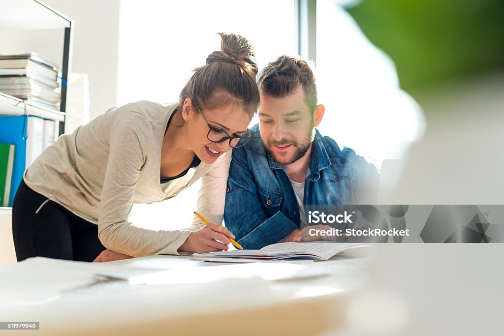 Checking documents Two young people looking at paper document Business Meeting Stock Photo