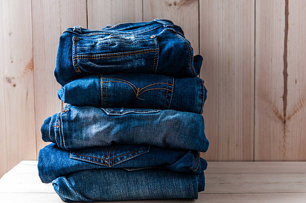istock Close up of many jeans trouser stack on wooden  background 511981980
