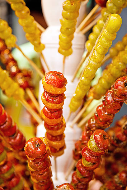 Red candy apple on holiday fair market closeup. Traditional sweet glazed apples for halloween treats.